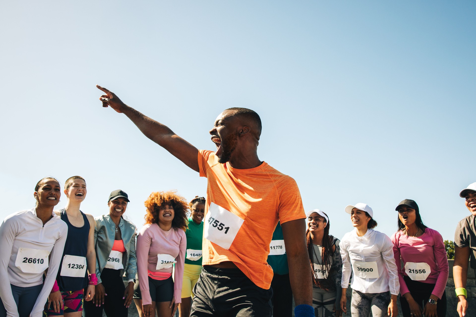 Group of diverse runners celebrating at outdoor marathon finish